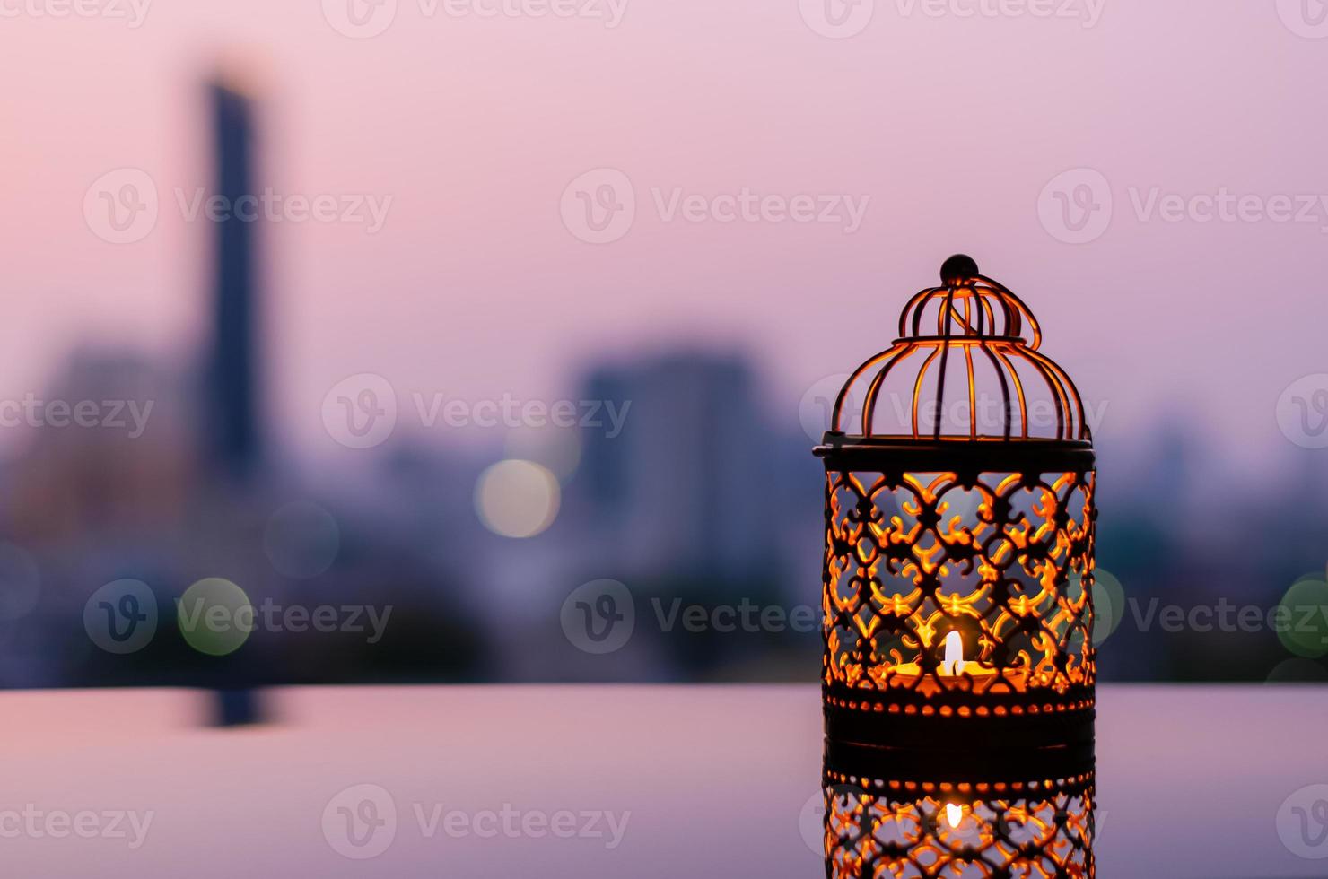 Golden lanterns with dawn sky and city bokeh light background for the Muslim feast of the holy month of Ramadan Kareem. photo