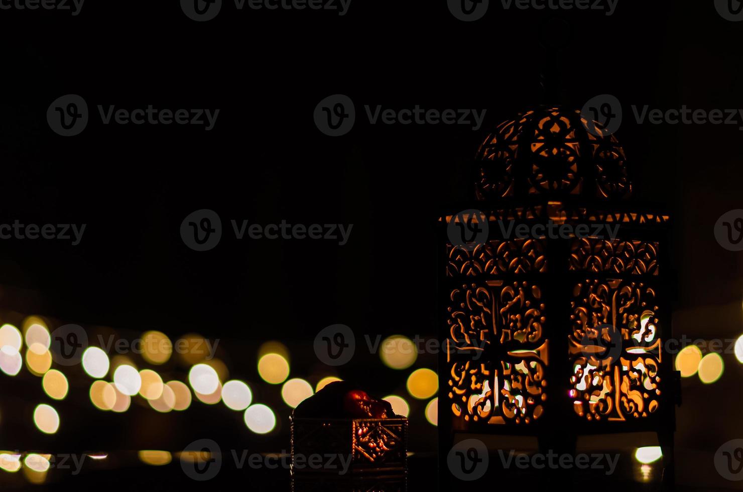 linterna y dátiles con luz bokeh en fondo oscuro para la fiesta musulmana del mes sagrado de ramadán kareem. foto