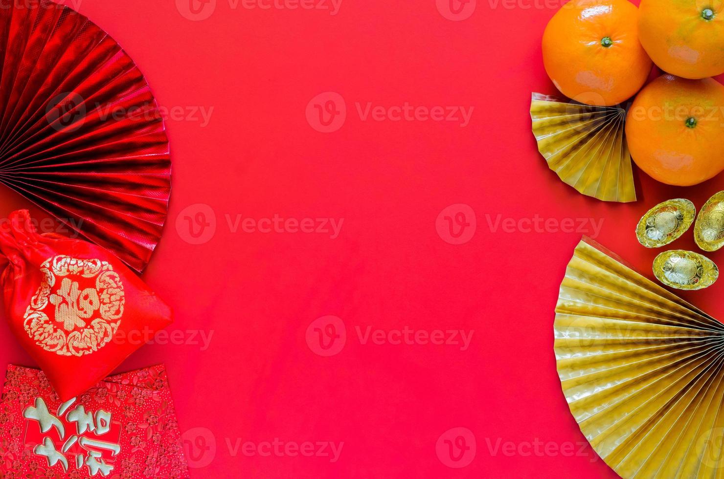 Chinese new year concept with red envelope packets or ang bao word mean auspice, red bag word mean wealth, ingots and oranges on red background with golden and red oriental fans. photo