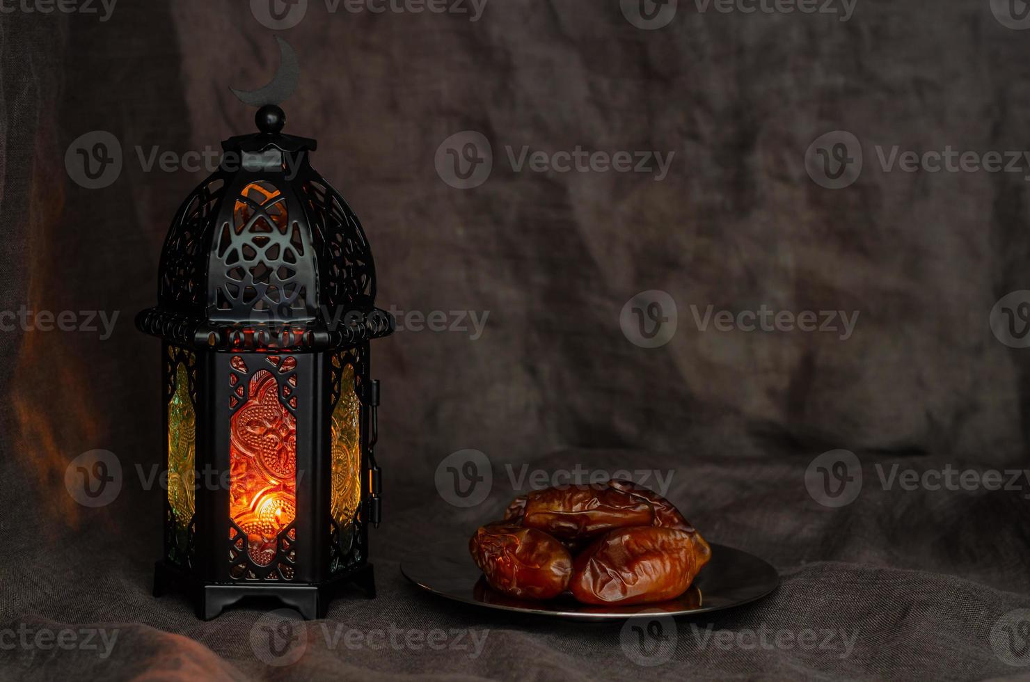 linterna negra y dátiles de frutas sobre fondo oscuro para la fiesta musulmana del mes sagrado de ramadán kareem. foto