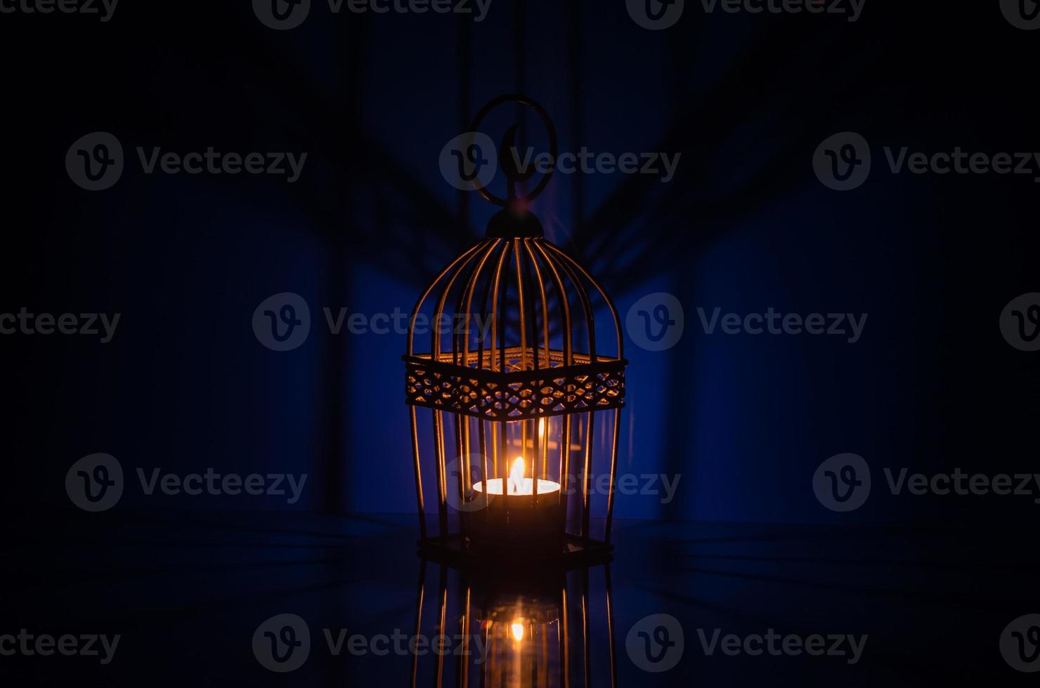 Black lantern with reflection from blue background for the Muslim feast of the holy month of Ramadan Kareem. photo