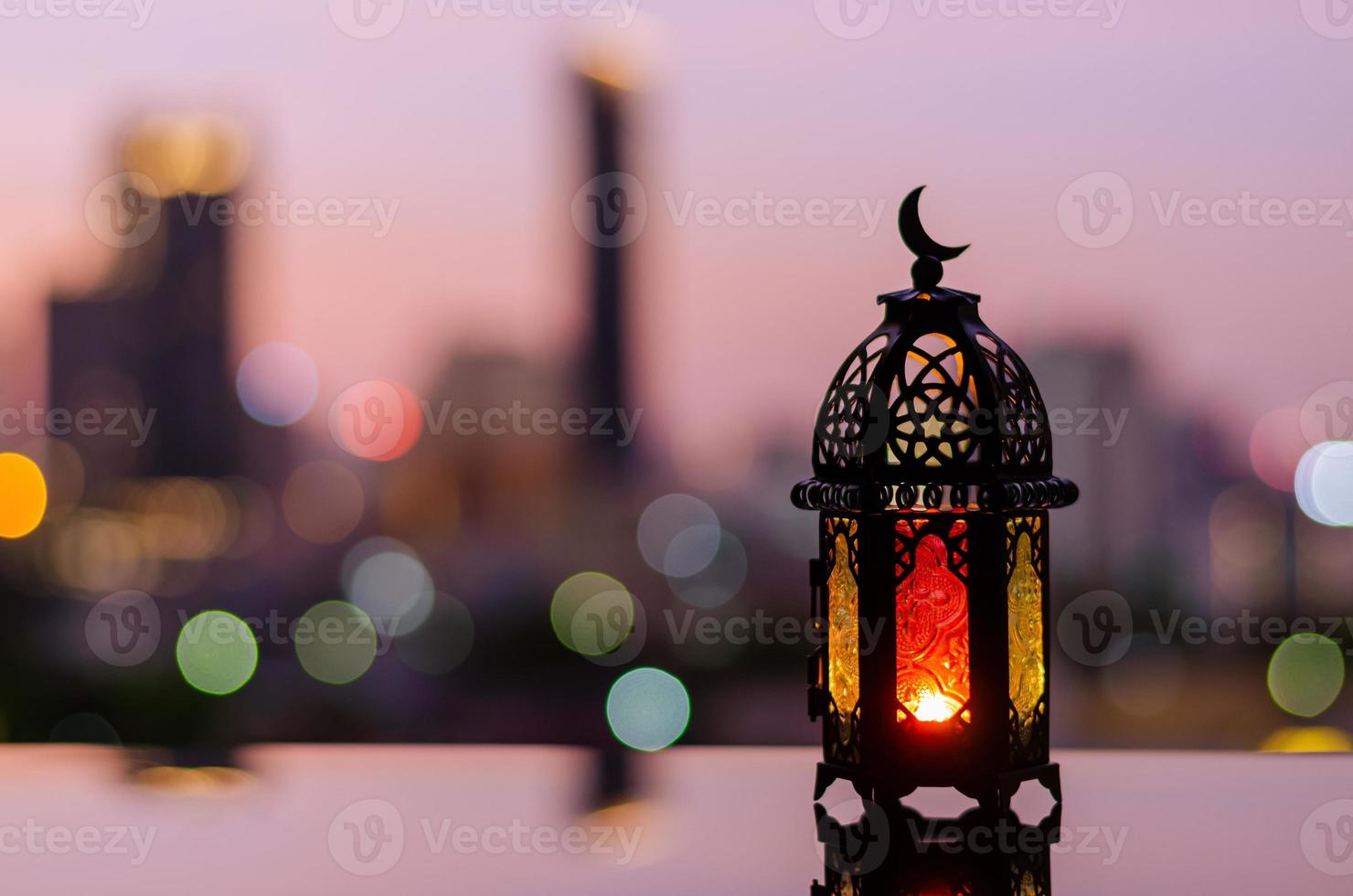 Lantern with dusk sky and city bokeh light background for the Muslim feast of the holy month of Ramadan Kareem. photo