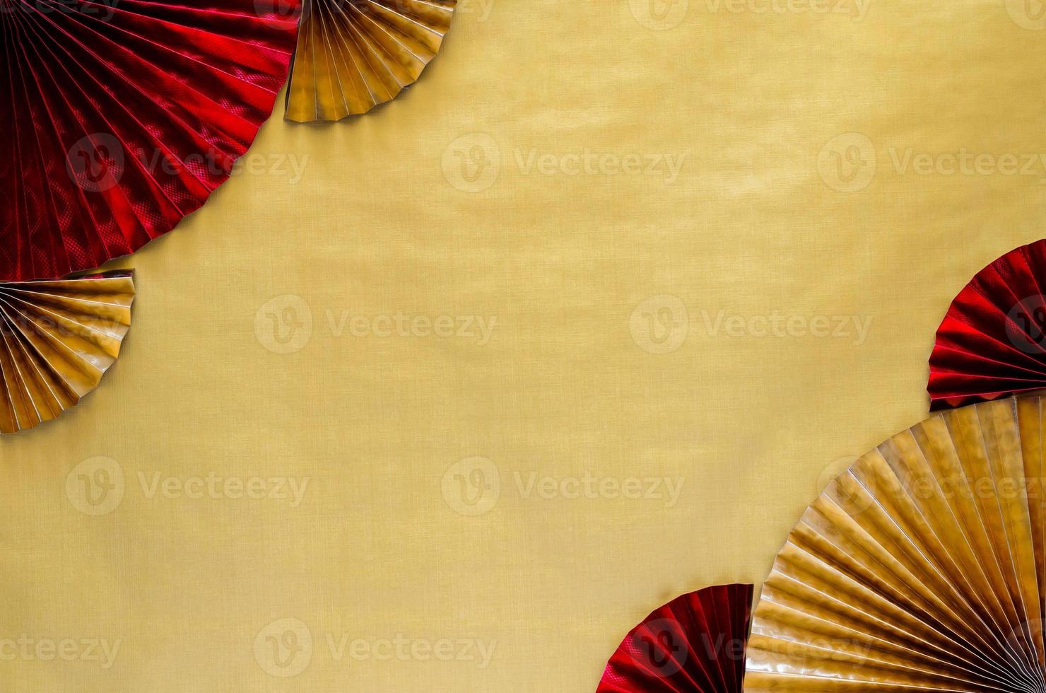 Chinese new year background concept with red and gold oriental fans on golden empty space background. photo