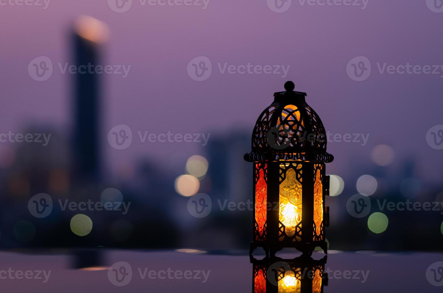 Lantern with dusk sky and city bokeh light background for the Muslim feast of the holy month of Ramadan Kareem. photo