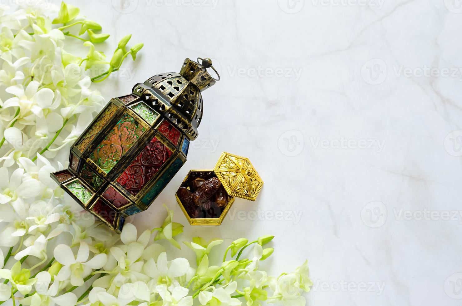Lantern and dates fruit on marble with white orchid flower for the Muslim feast of the holy month of Ramadan Kareem. photo
