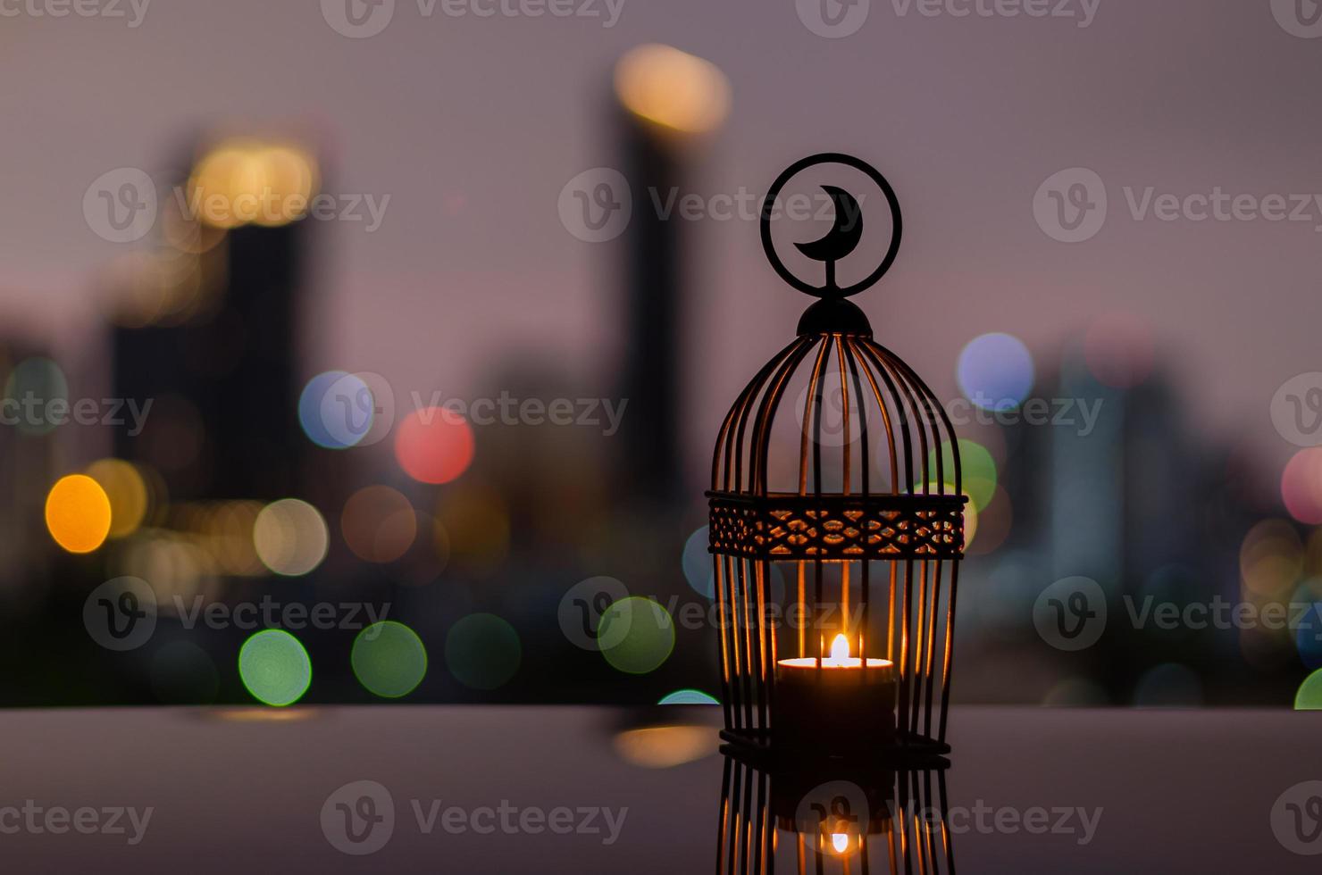 farol con cielo al atardecer y fondo de luz bokeh de la ciudad para la fiesta musulmana del mes sagrado del ramadán kareem. foto