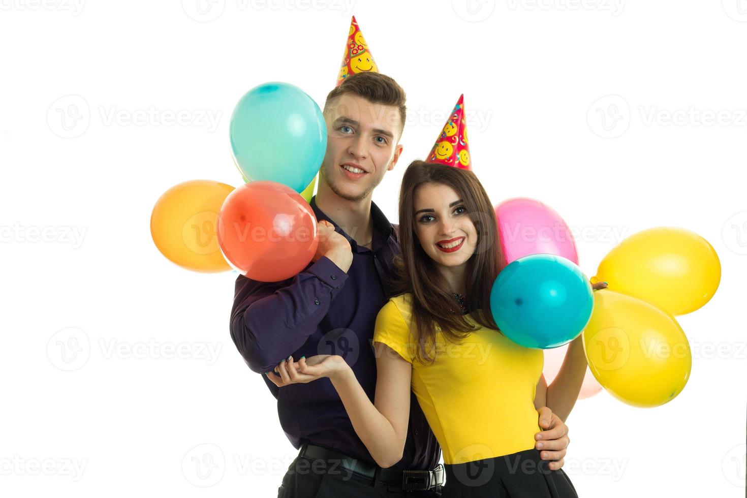 chico y chica graciosos sonriendo y sosteniendo mucho aire de bolas de colores foto