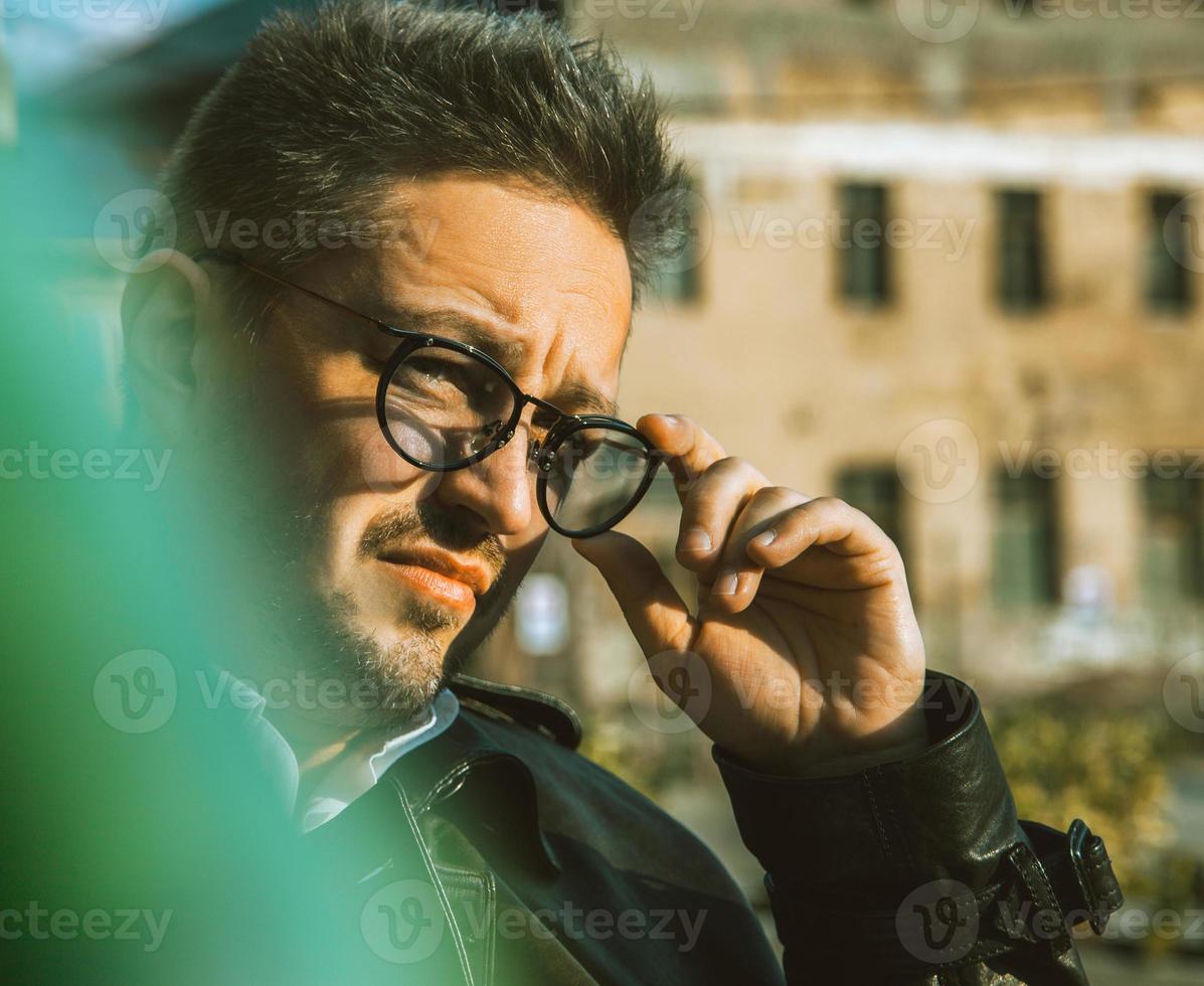 Close Up retrato de macho adulto en gafas de sol mirando al aire libre foto