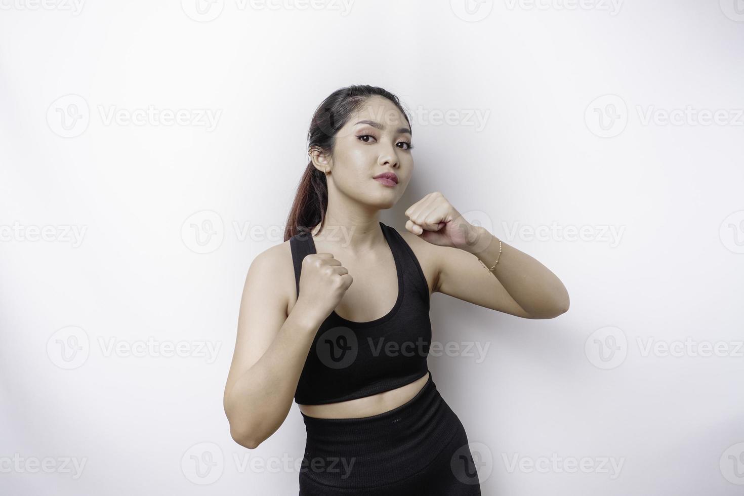 Hermosa luchadora asiática deportiva entrena boxeo en estudio sobre fondo blanco. concepto de artes marciales foto