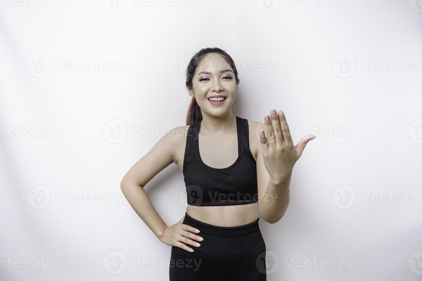 Young Asian beautiful sporty woman over isolated white background inviting to join with hand. Happy that you came photo