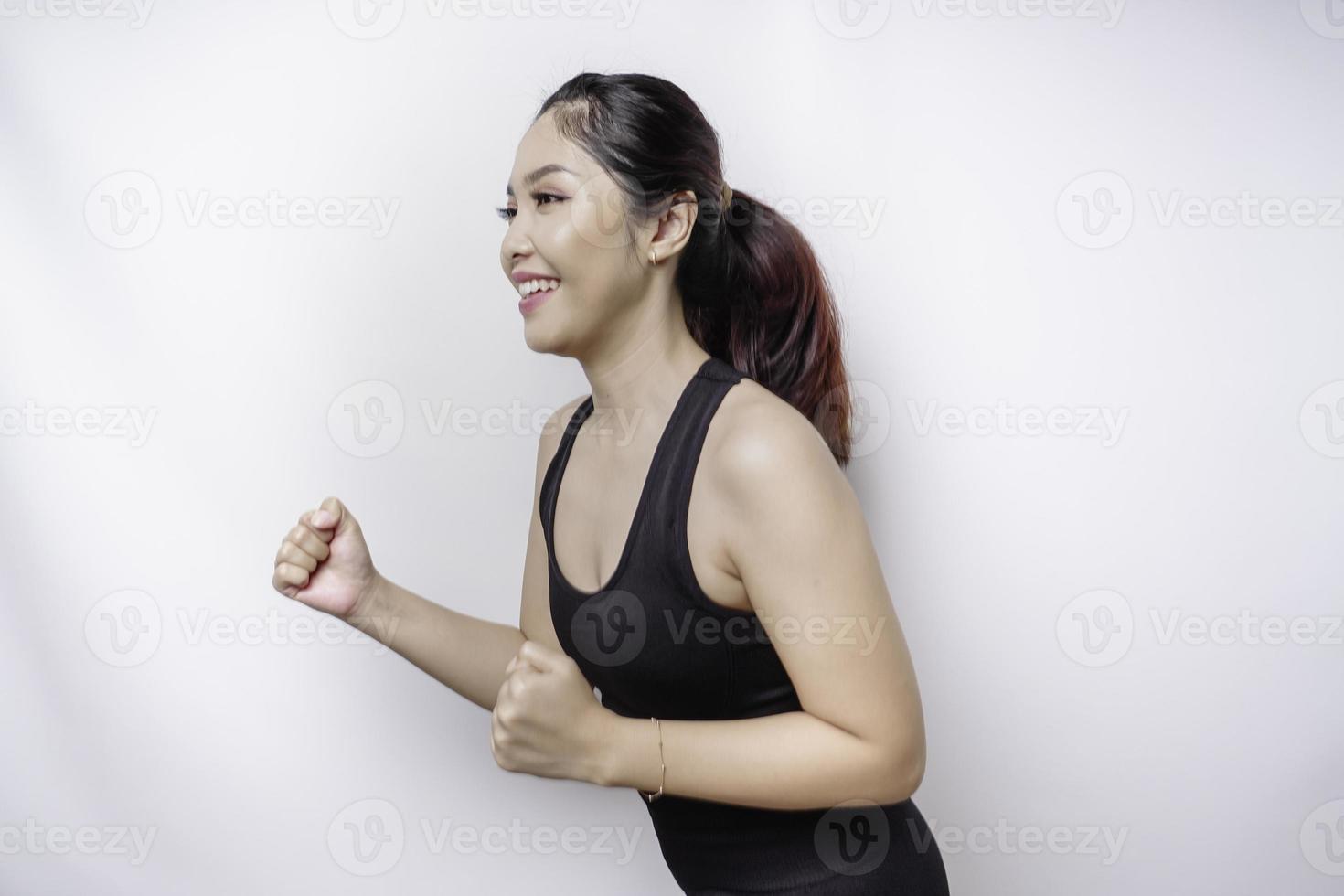 A sporty Asian woman wearing sportswear is running, isolated by white background photo