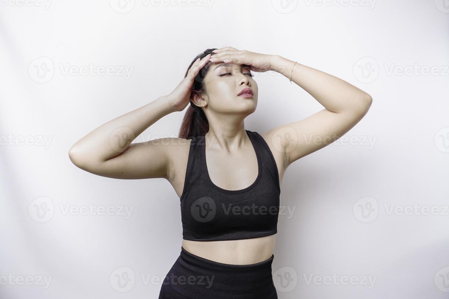 A portrait of an sporty Asian woman wearing a sportswear isolated by white background looks depressed photo
