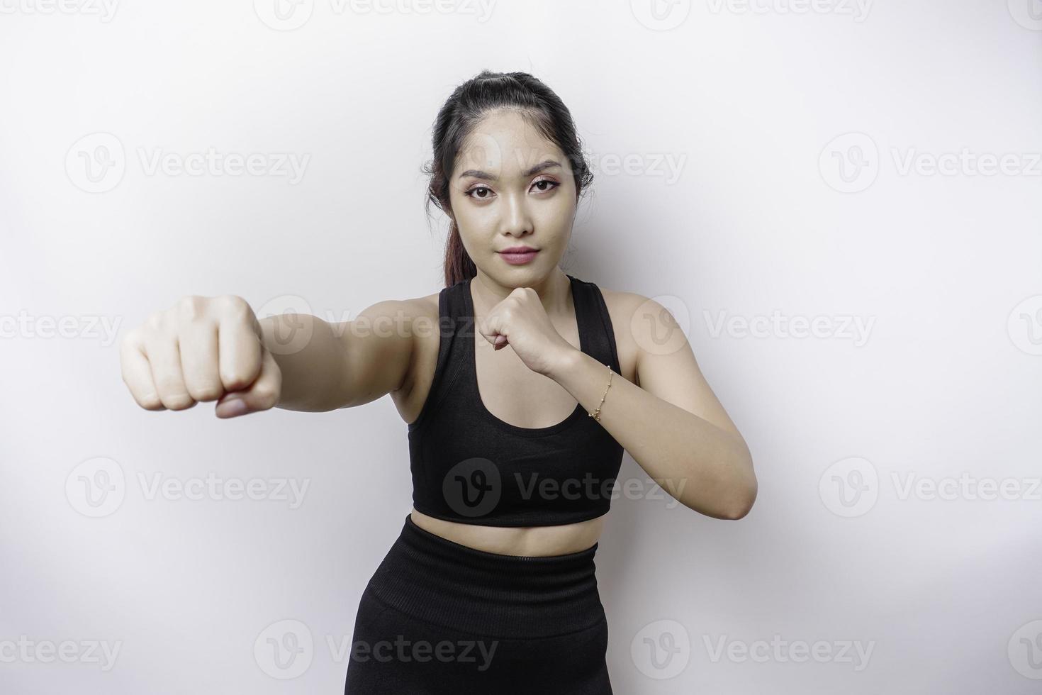 Hermosa luchadora asiática deportiva entrena boxeo en estudio sobre fondo blanco. concepto de artes marciales foto