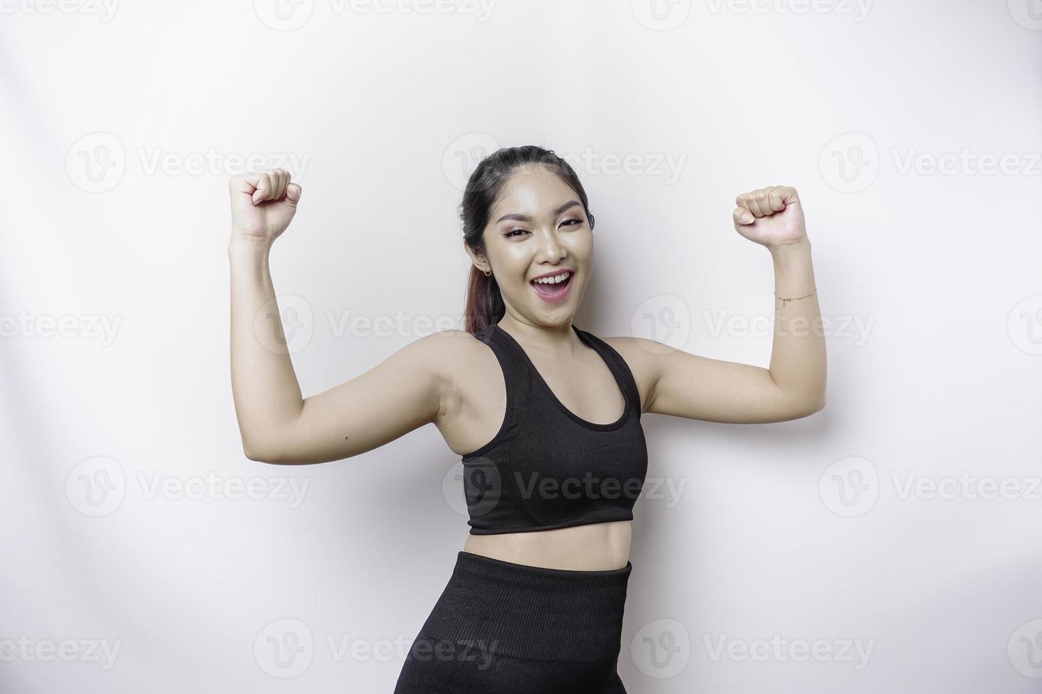 una joven mujer asiática deportiva con una expresión feliz y exitosa que usa ropa deportiva aislada de fondo blanco foto