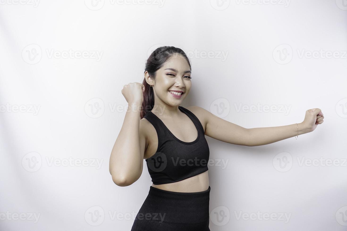 una joven mujer asiática deportiva con una expresión feliz y exitosa que usa ropa deportiva aislada de fondo blanco foto