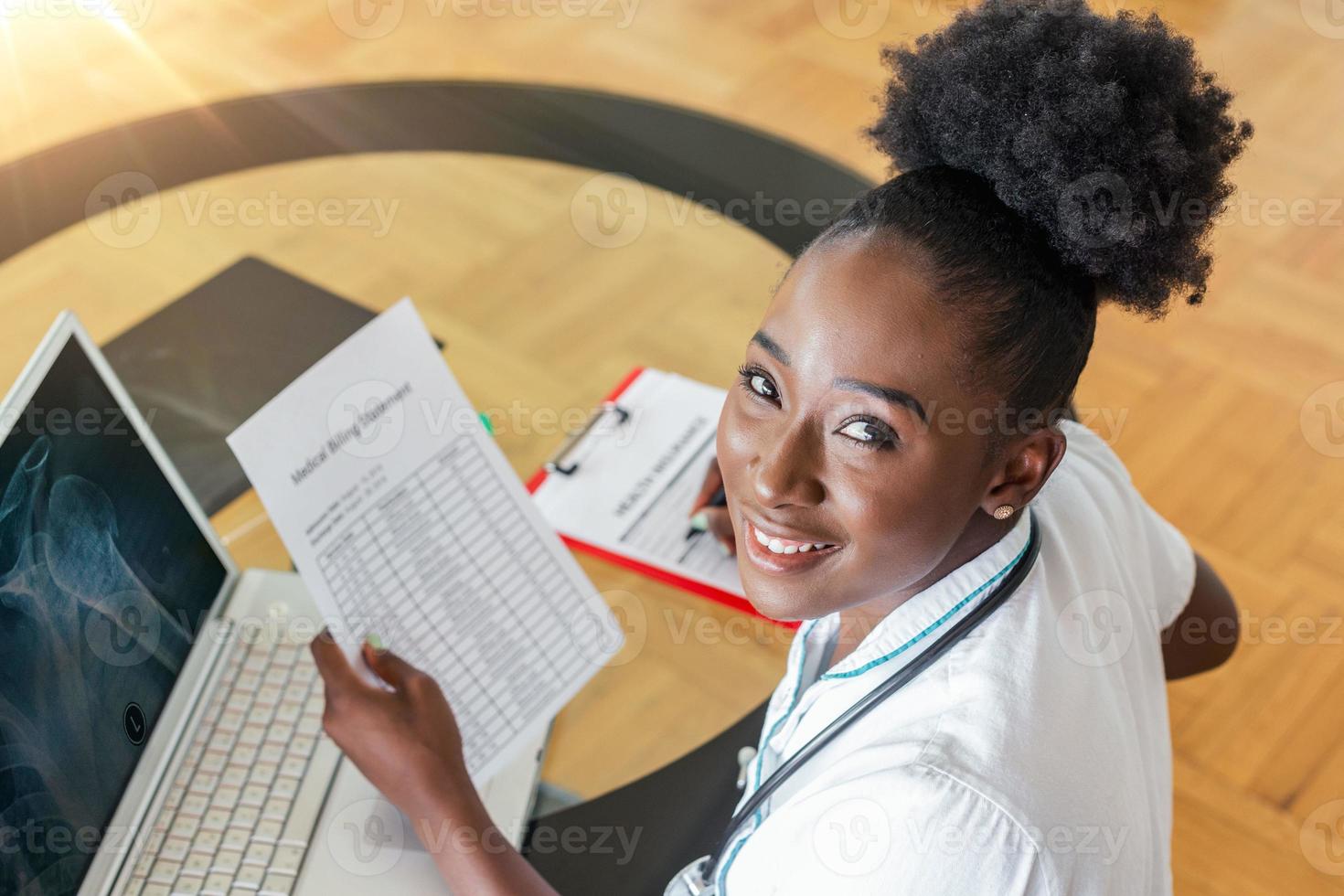 Healthcare costs and fees concept. Top view of smart doctor calculating medical costs in modern hospital. Doctor completing a Medical Claim Form ,Stethoscope photo