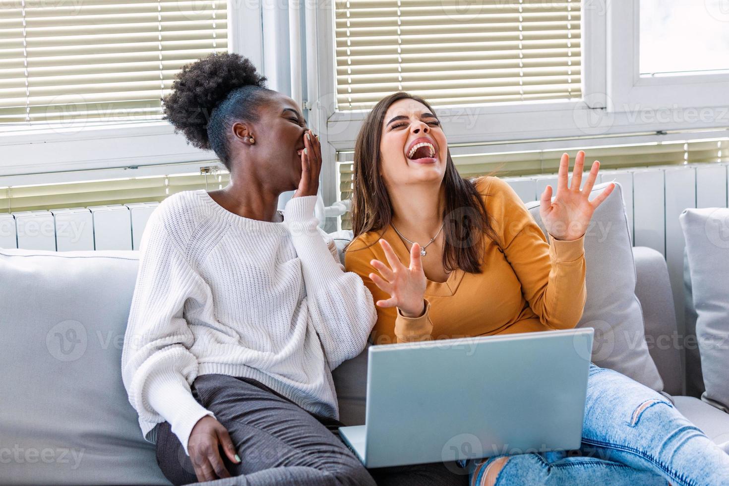 novia viendo una película muy divertida en la computadora portátil. mujeres jóvenes sonrientes relajándose y viendo películas en casa, amigas descansando después de una semana dura, copiando espacio foto