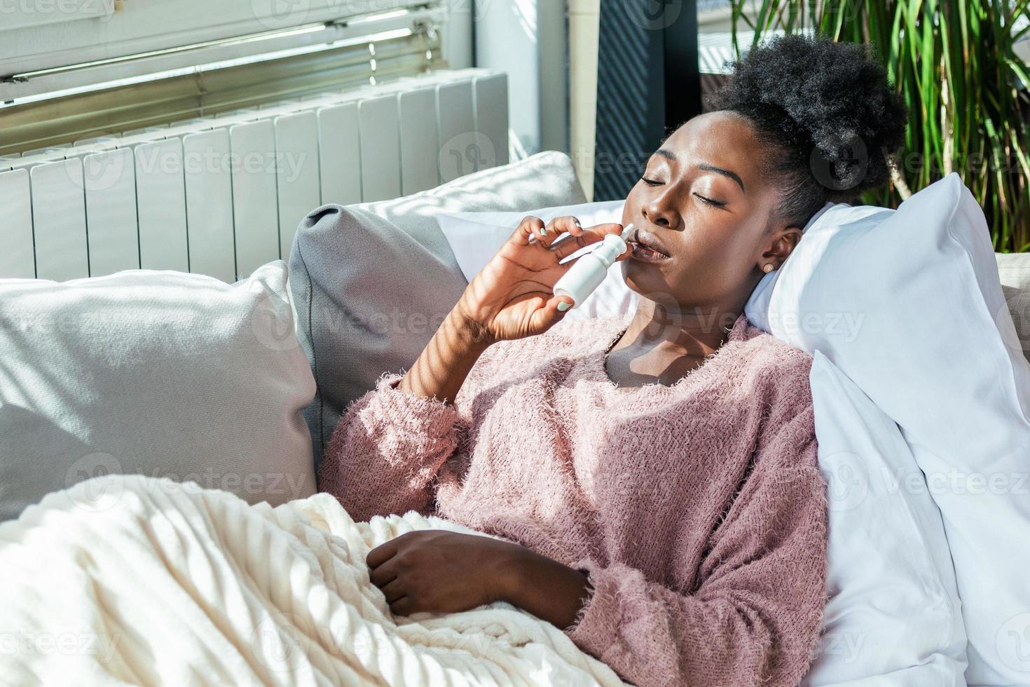 la mujer tiene gripe y usa aerosol nasal para ayudarse a sí misma. mujer usando spray nasal. aerosol nasal para ayudar a un resfriado. enfermo con rinitis que gotea la nariz. mujer aplica spray nasal foto