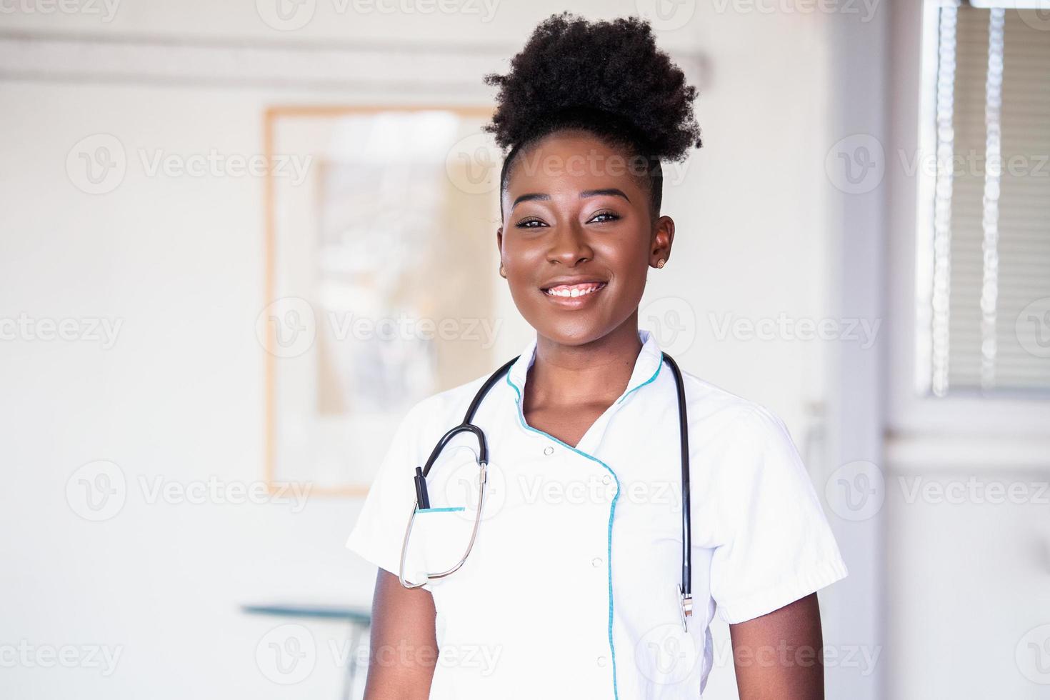 African American Doctor working in hospital , Healthcare and medical concept Stethoscope around her neck. Female black doctor filling up medical form at clipboard while standing straight in hospital photo