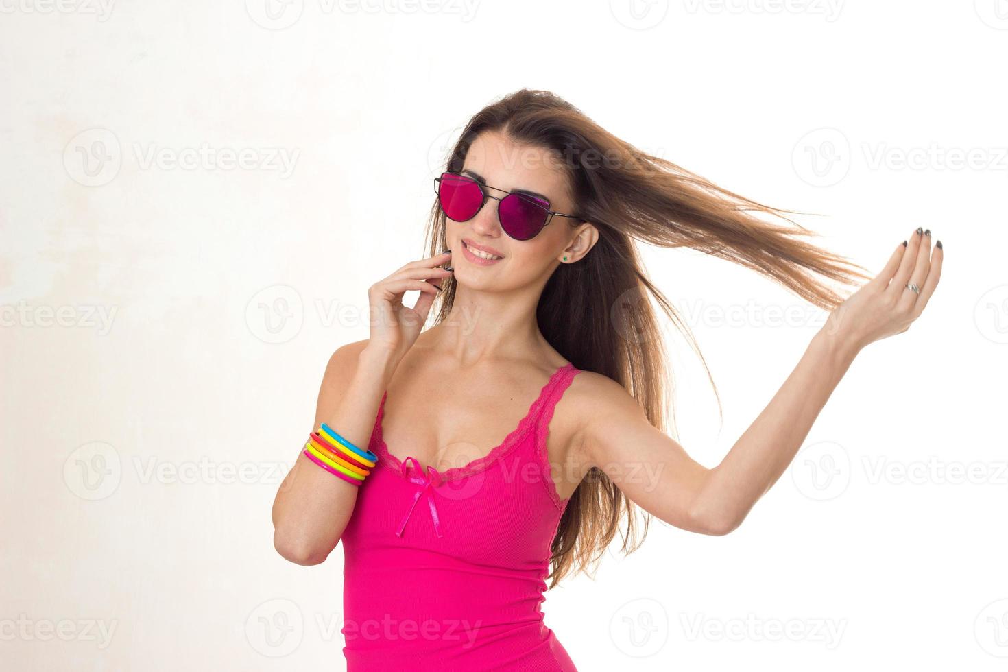 beauty young brunette woman in pink mirror sunglasses and shirt posing and smiling on camera isolated on white background photo