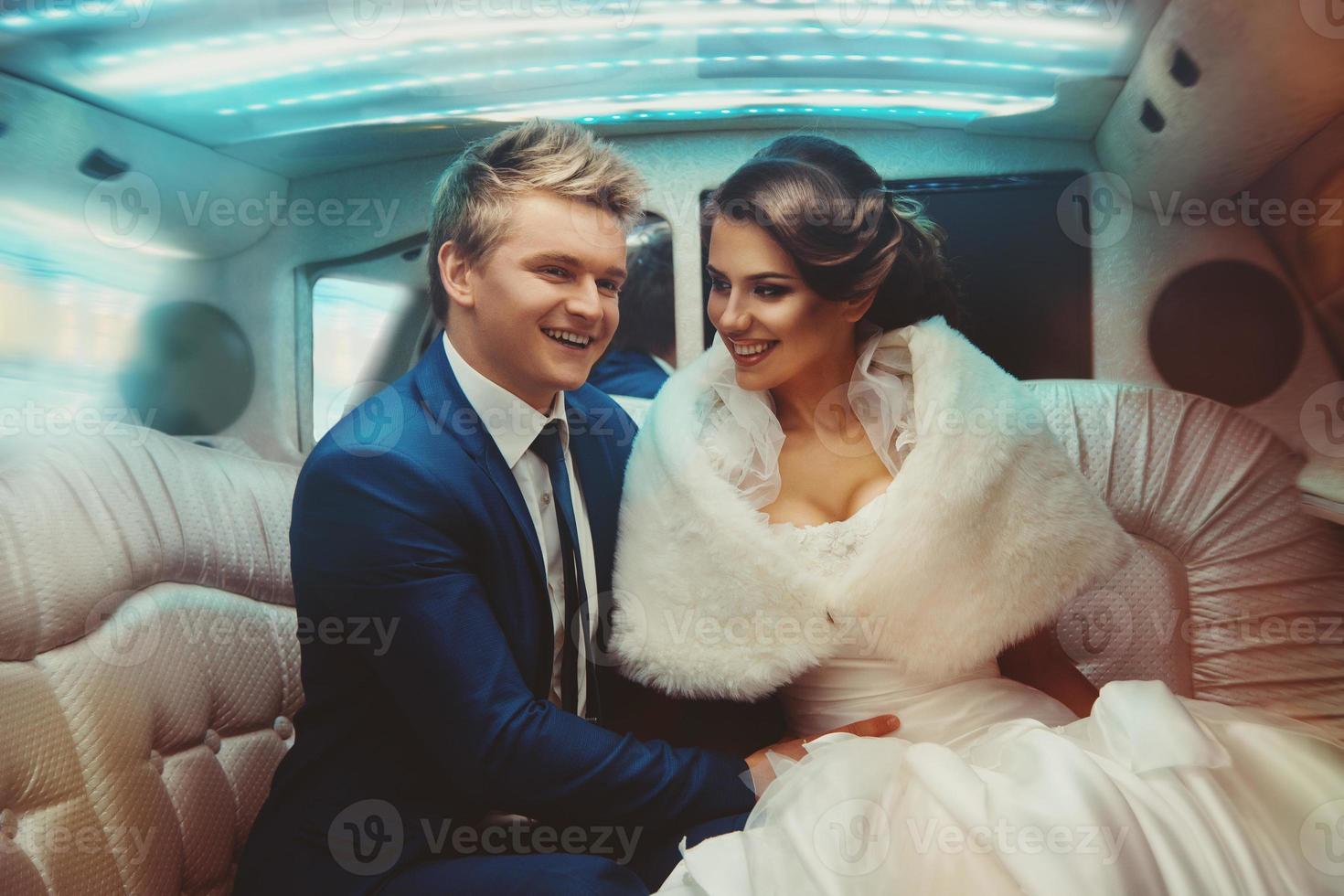 Lovely just merried couple driving in limousine photo
