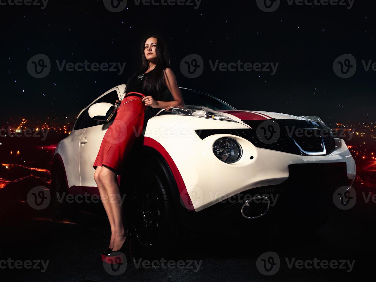 Charming woman on high heels standing near car photo