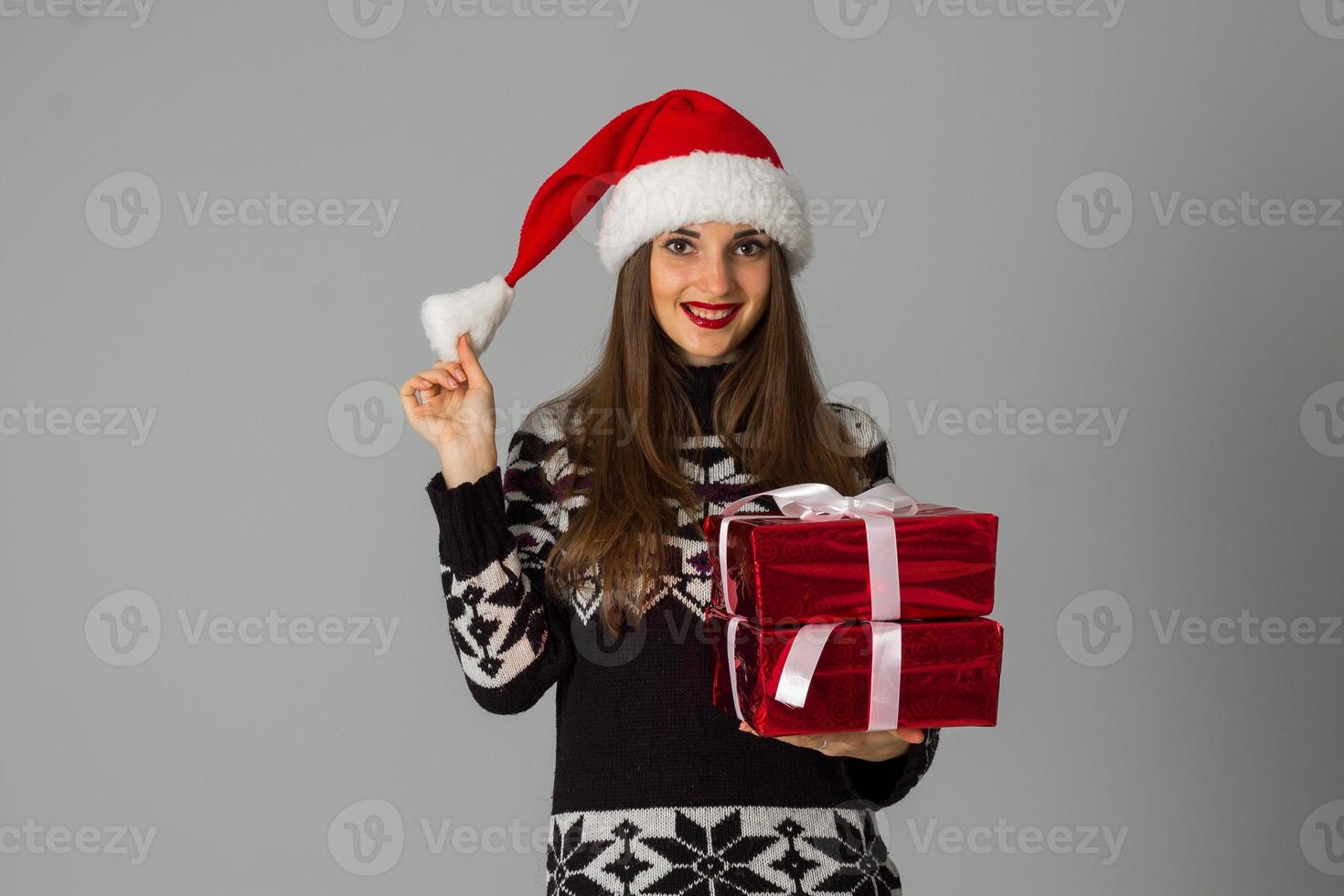 woman in warm sweater and santa hat with red gift photo