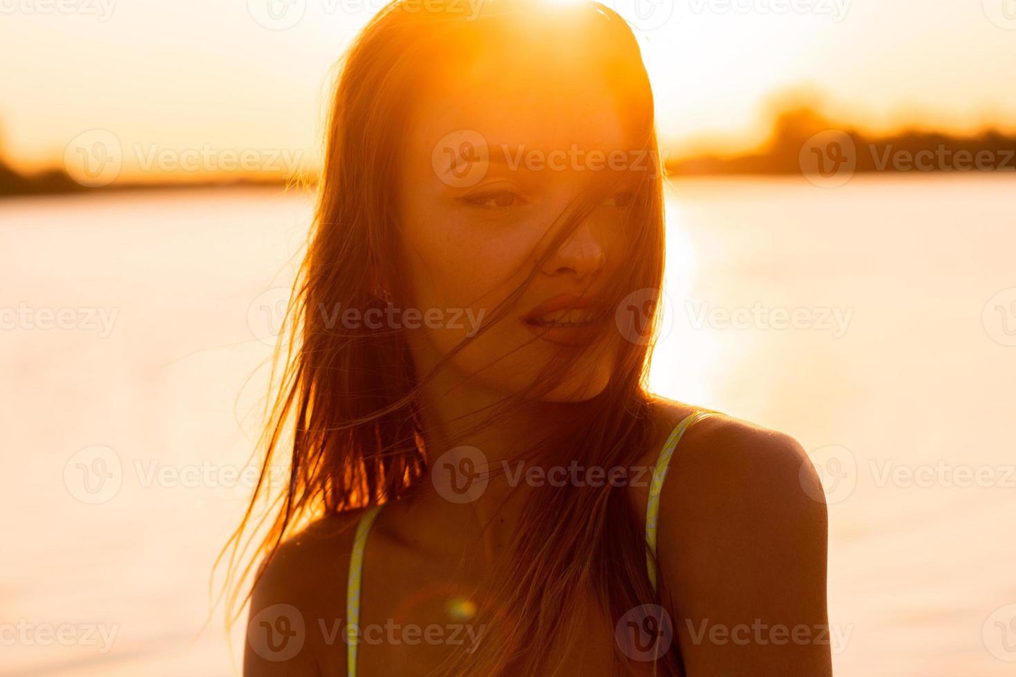 Sexual young lady in the sea at warm sunset photo