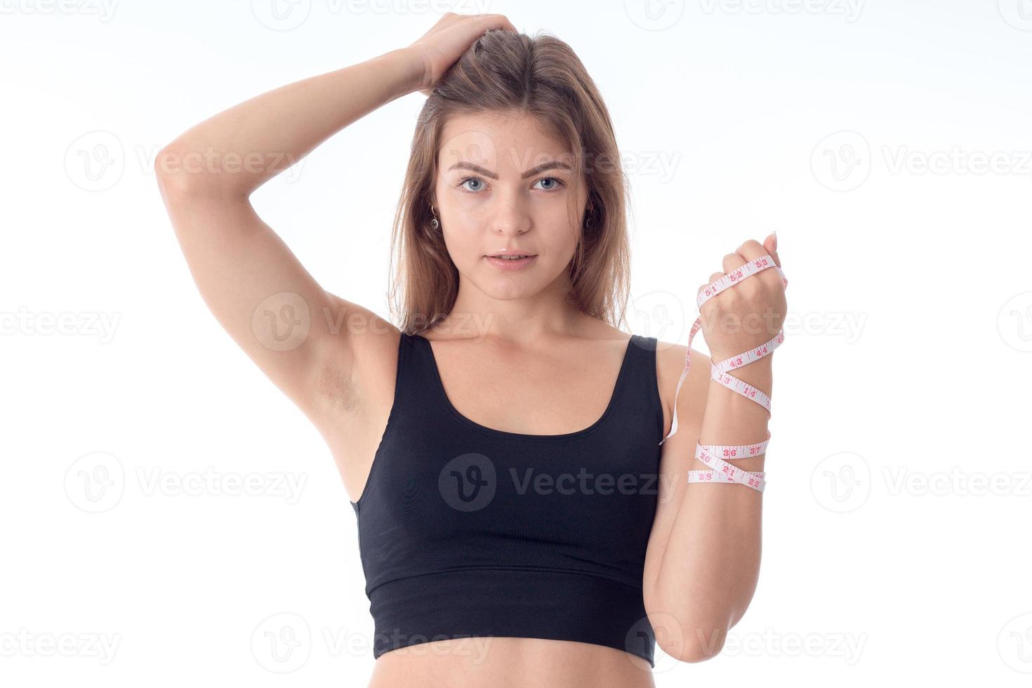 close-up of young athletic girl who keeps her hair with one hand looking forward smiling photo