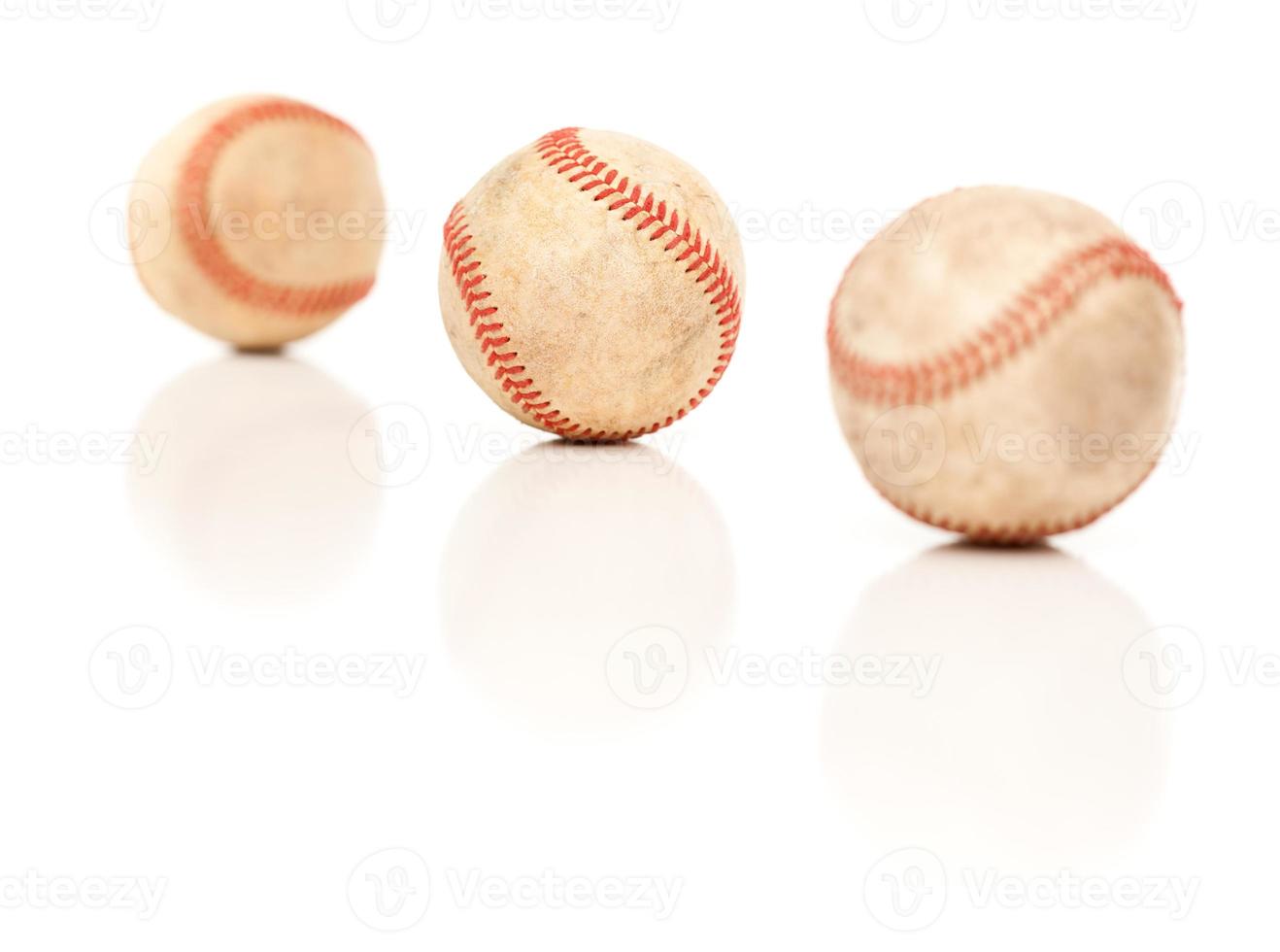 tres pelotas de béisbol aisladas en blanco reflectante foto
