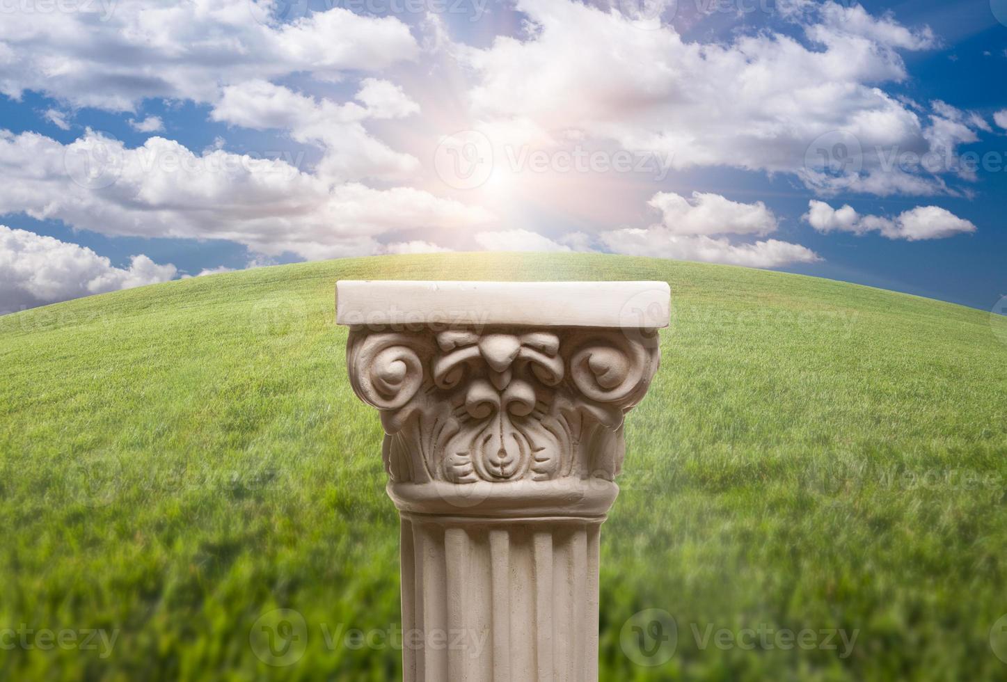 Ancient Replica Column Pillar Over Grass and Clouds photo