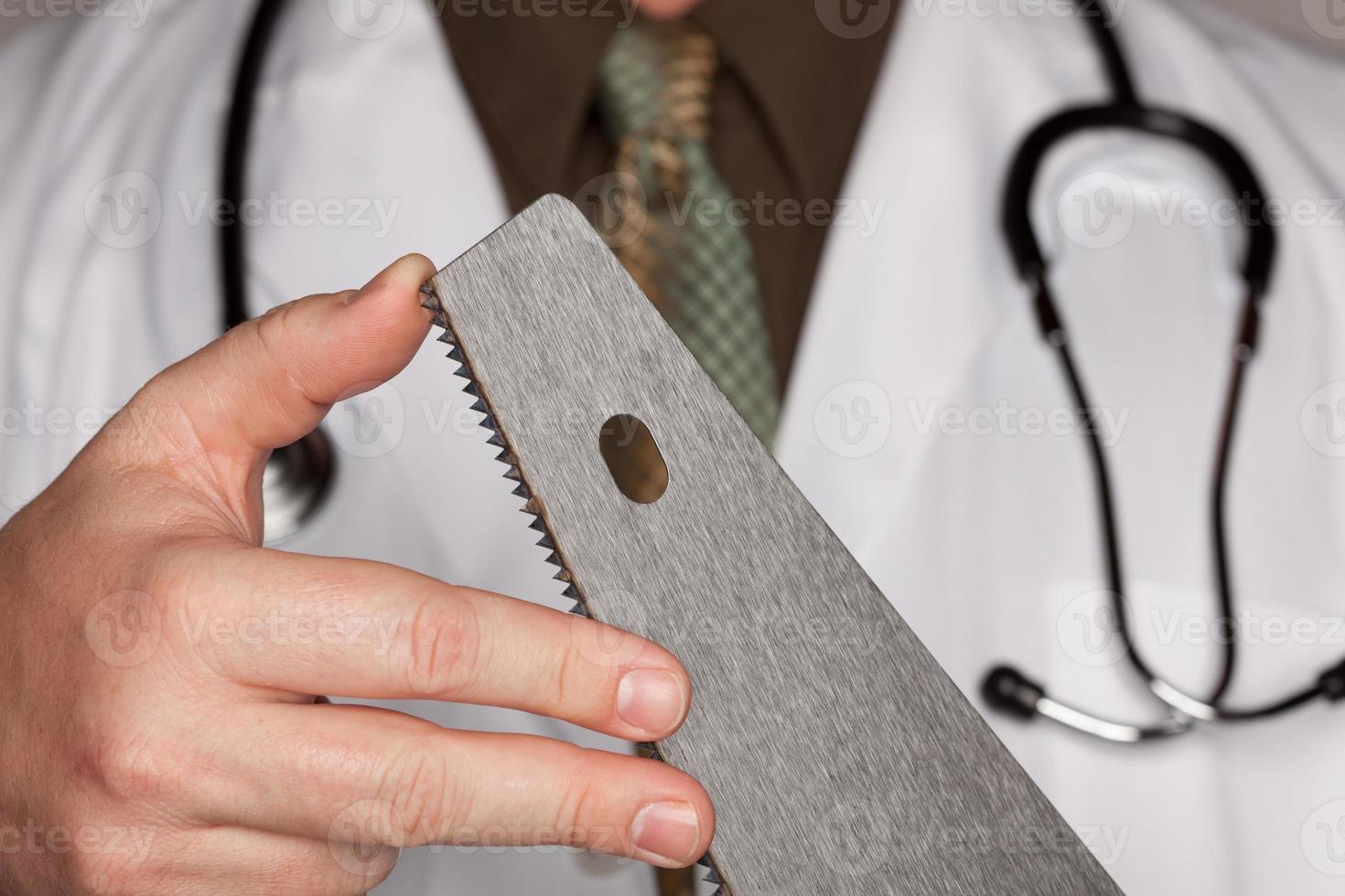 Doctor with Stethoscope Holding A Sharp Saw photo