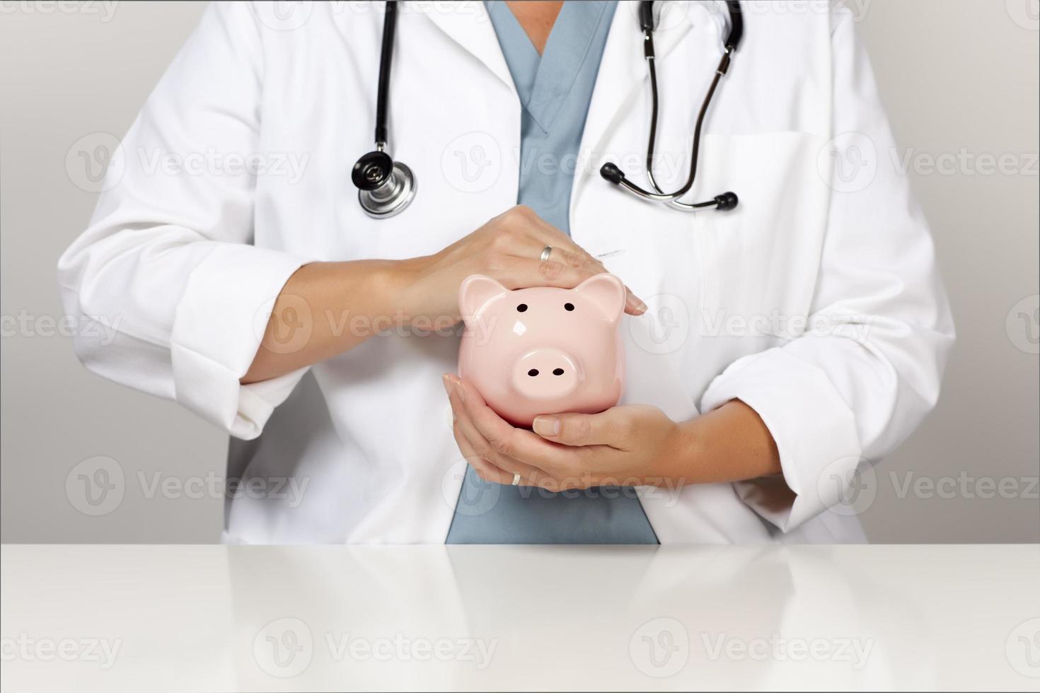Doctor with Stethoscope Holding Piggy Bank Abstract photo