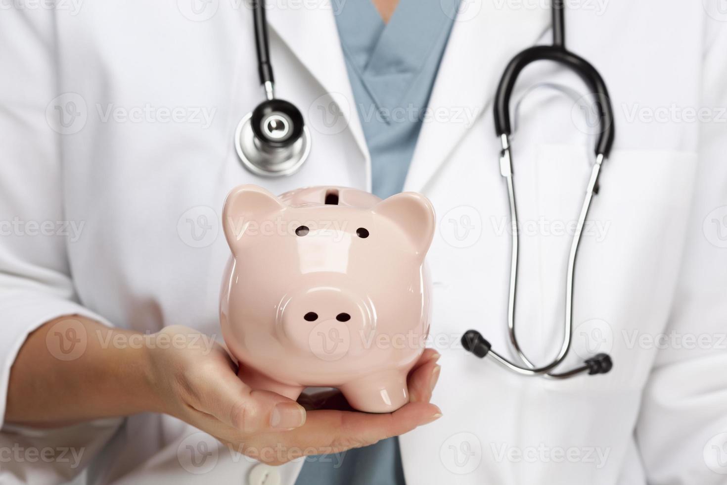 Doctor with Stethoscope Holding Piggy Bank Abstract photo