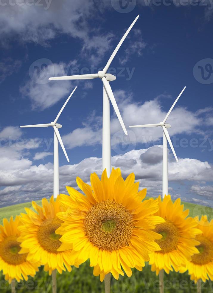 turbinas de viento contra el cielo dramático con girasoles brillantes foto