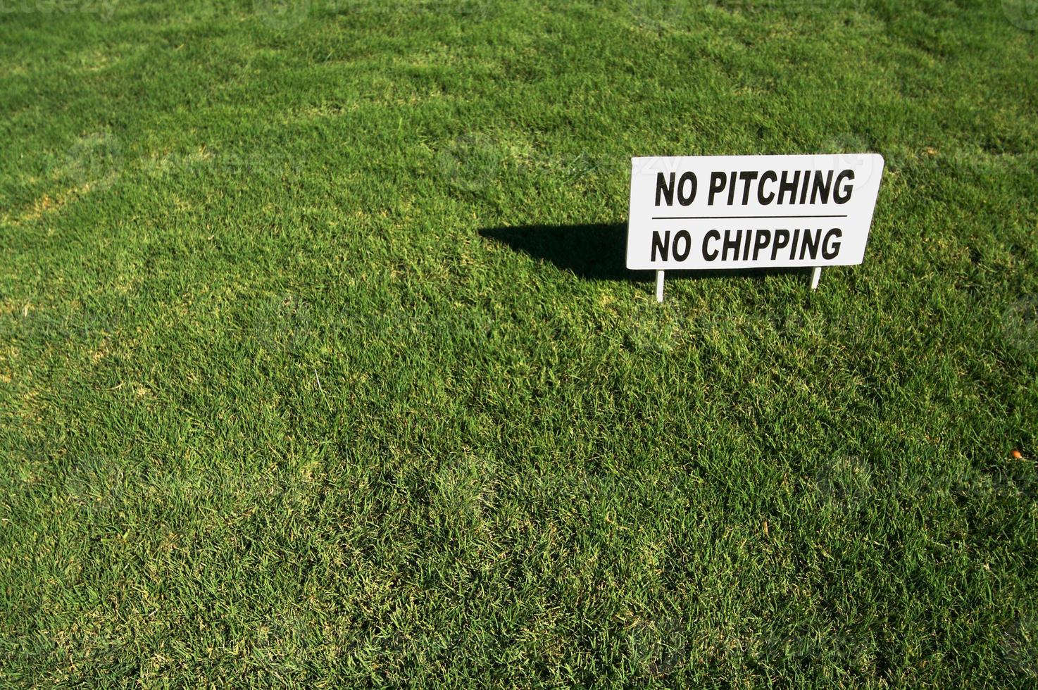 No Pitching or Chipping Sign on Lush Green Grass photo