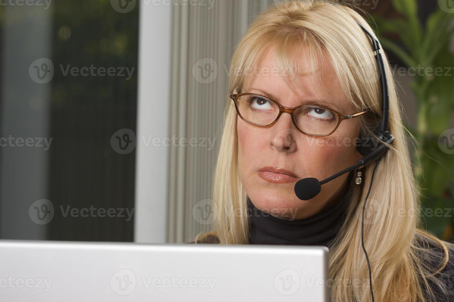 atractiva mujer de negocios con auriculares de teléfono foto