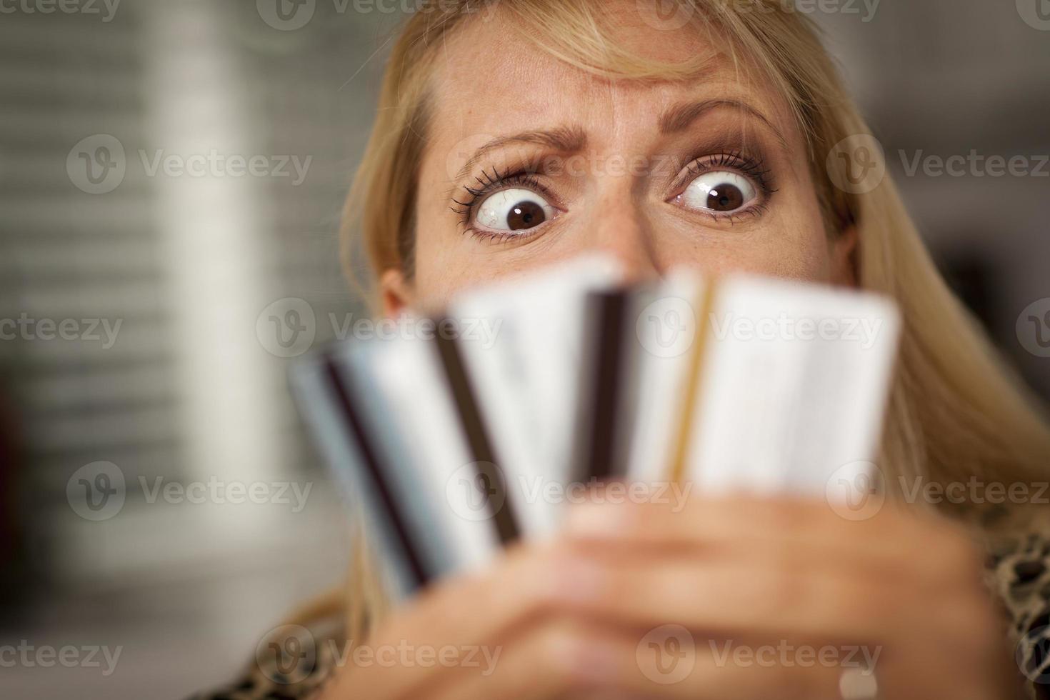 Upset Woman Glaring At Her Many Credit Cards photo