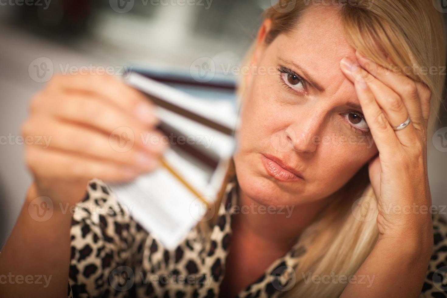 Upset Woman Glaring At Her Many Credit Cards photo