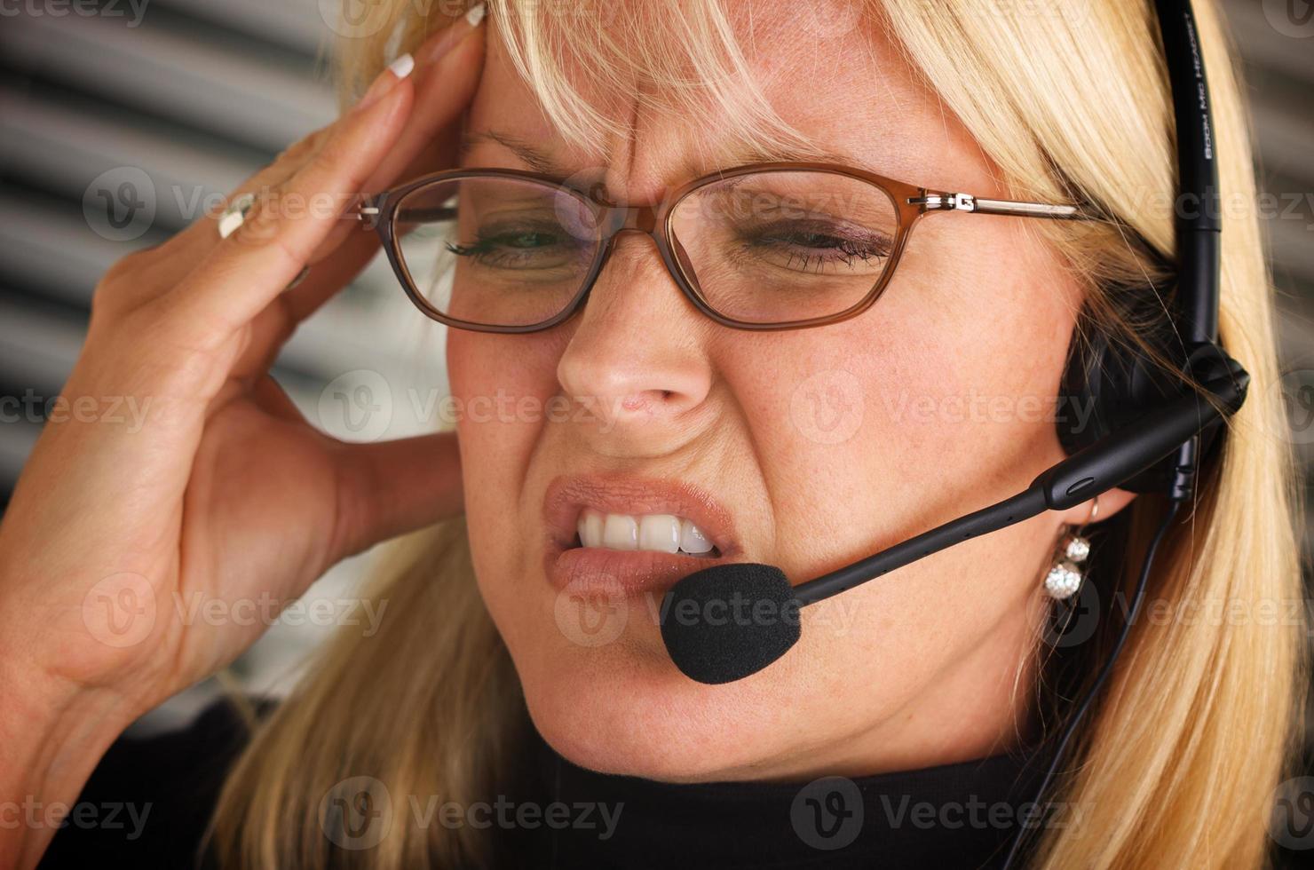 mujer de negocios con auriculares y dolor de cabeza foto