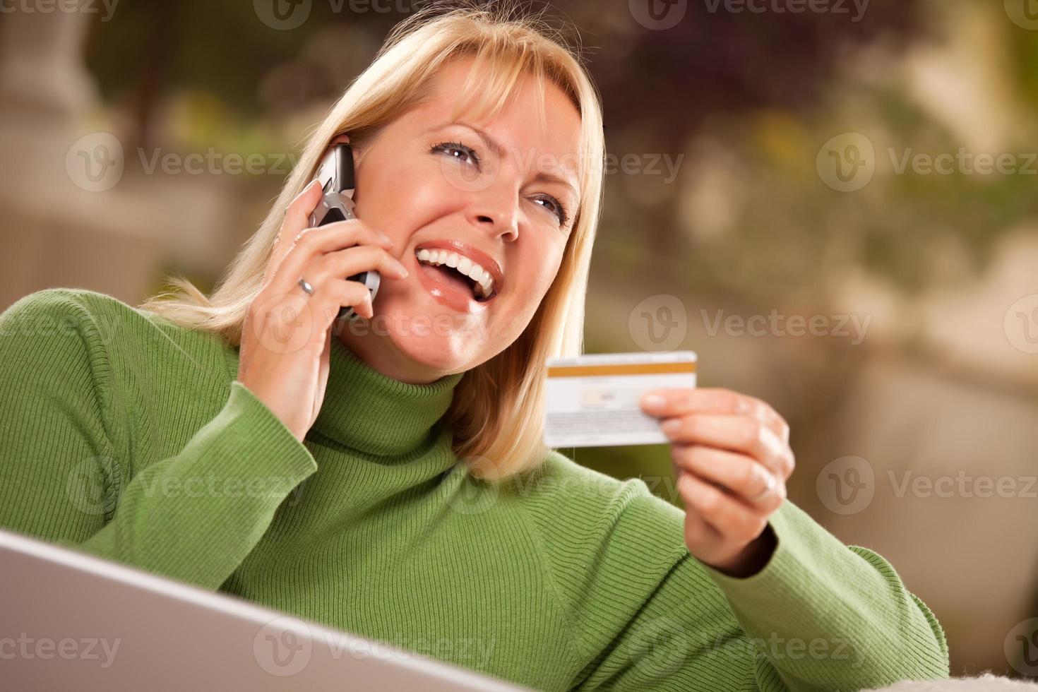 Cheerful Woman on Phone and Laptop with Credit Card photo