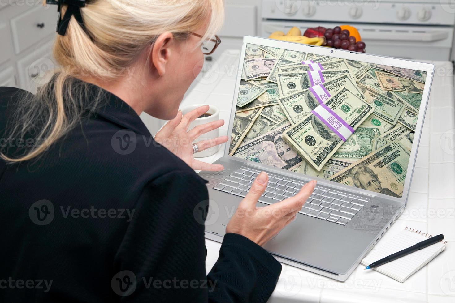 Excited Woman In Kitchen Using Laptop - Success photo