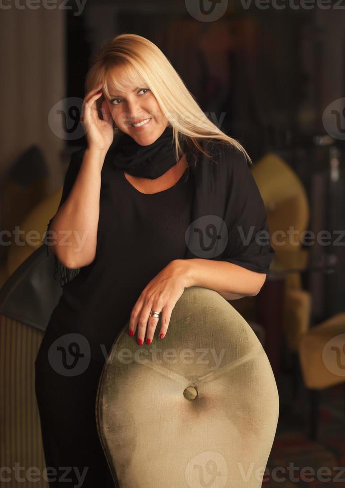 Beautiful Blonde Woman Standing Near Chair photo