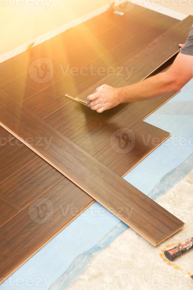 Man Installing New Laminate Wood Flooring photo