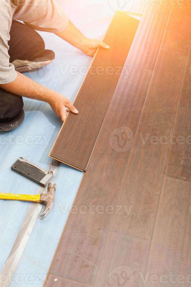 Man Installing New Laminate Wood Flooring photo