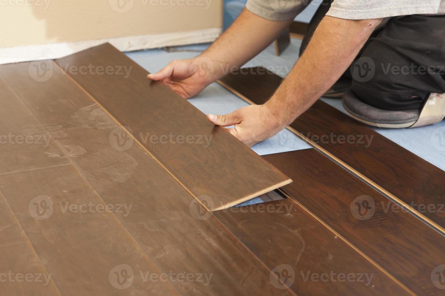 Man Installing New Laminate Wood Flooring photo