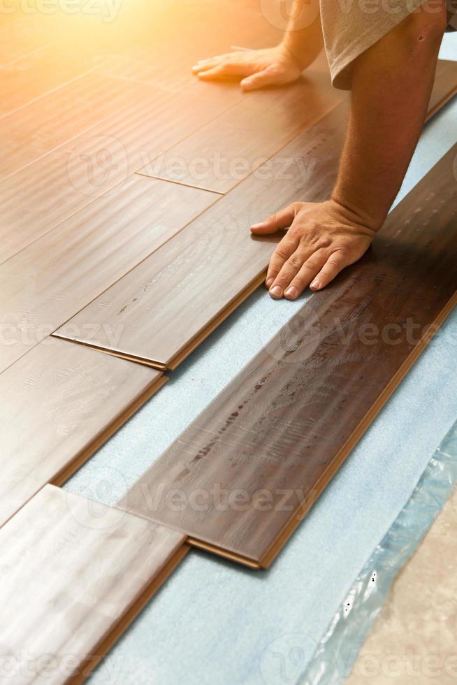Man Installing New Laminate Wood Flooring photo