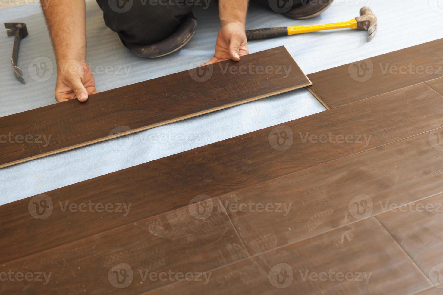 Man Installing New Laminate Wood Flooring photo