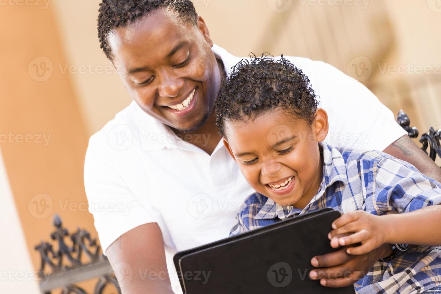 Mixed Race Father and Son Using Touch Pad Computer Tablet photo