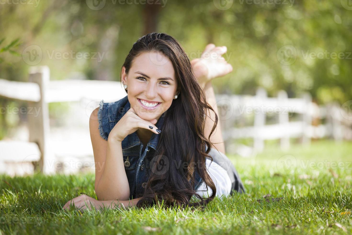 Attractive Mixed Race Girl Portrait Laying in Grass photo
